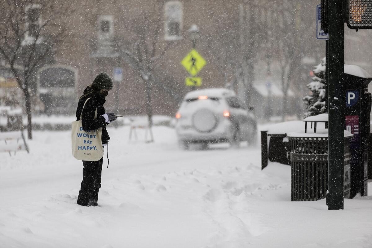 Clic para aumentar Katarina Hahn checks her phone before heading into work Wednesday morning after Flagstaff received multiple inches of snow overnight.
