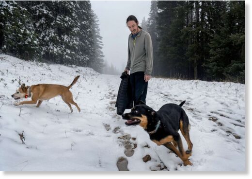 Clic para aumentar Chris Dugan, from Santa Fe, plays with his dogs at the Ski Santa Fe, on Oct. 17, 2022, in Sante Fe, N.M.