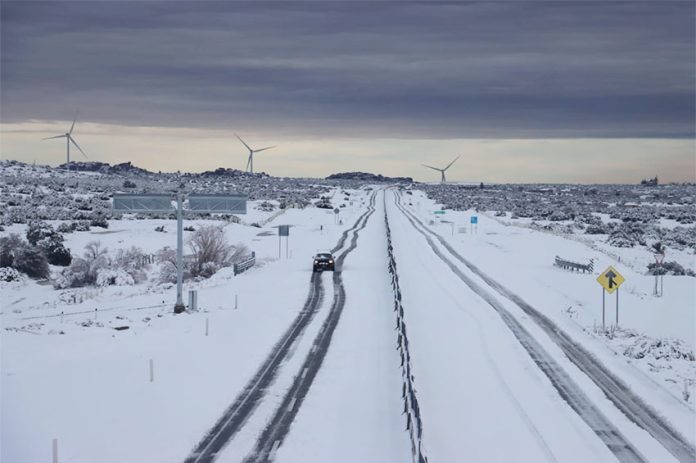 A lone car navigates a snowy highway near La Rumorosa, Baja California.