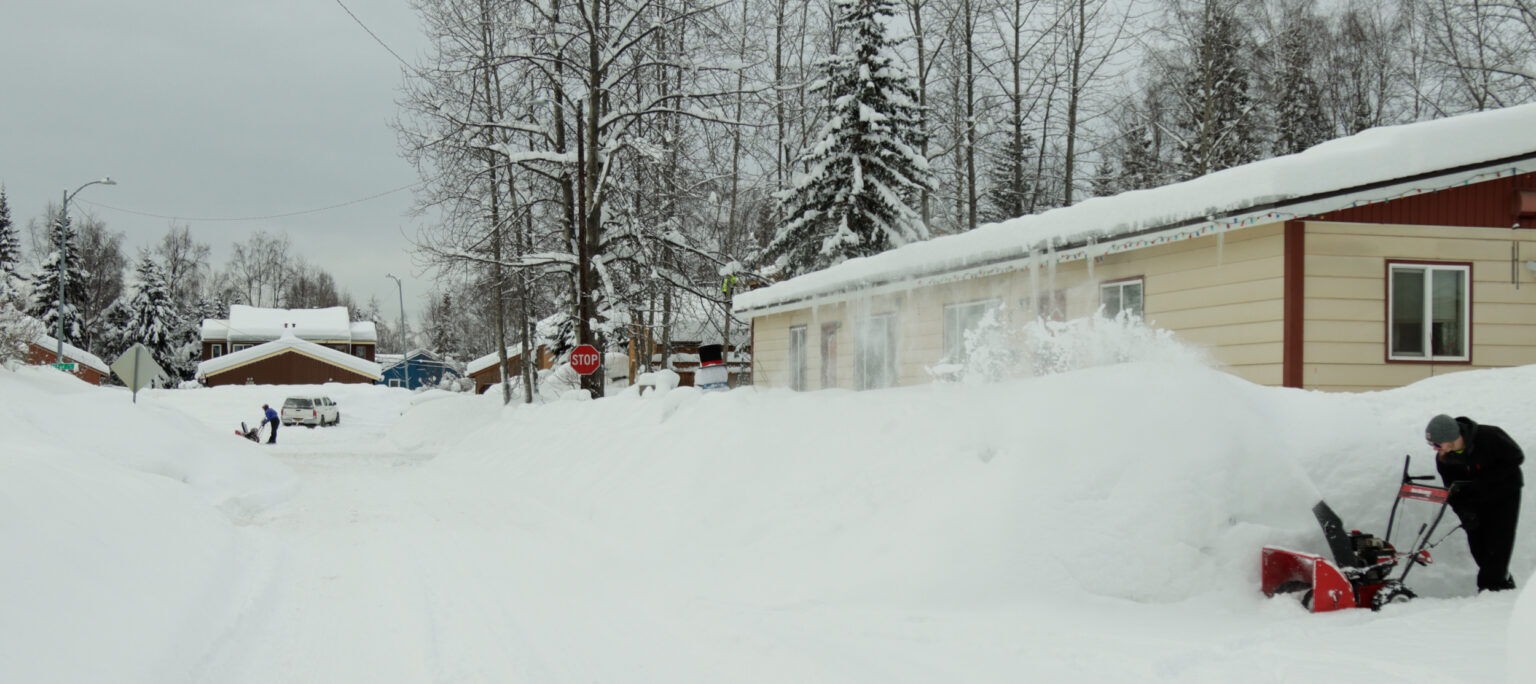 Anchorage residents clear snow on Monday.