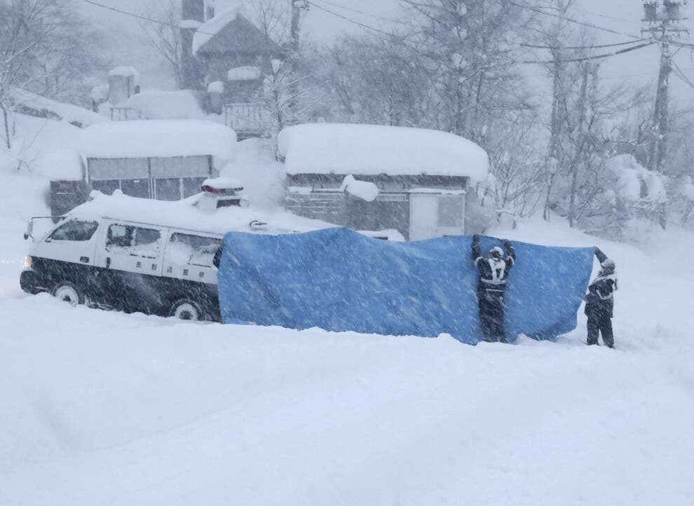 File - Rescue crews work to recover bodies after an avalanche