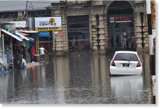 Widespread: Lower Henry Street leading onto South Quay, left, was covered in water, making it impassable to both vehicular and pedestrian traffic following yesterday’s heavy rains in downtown Port of Spain.