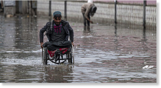 File photo: A man on a wheelchair makes his way through flood waters after heavy rains in Kabul on April 24, 2022