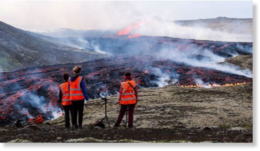 Observers from the University of Iceland watch a volcanic eruption near Litli Hrutur, Iceland on July 10, 2023.
