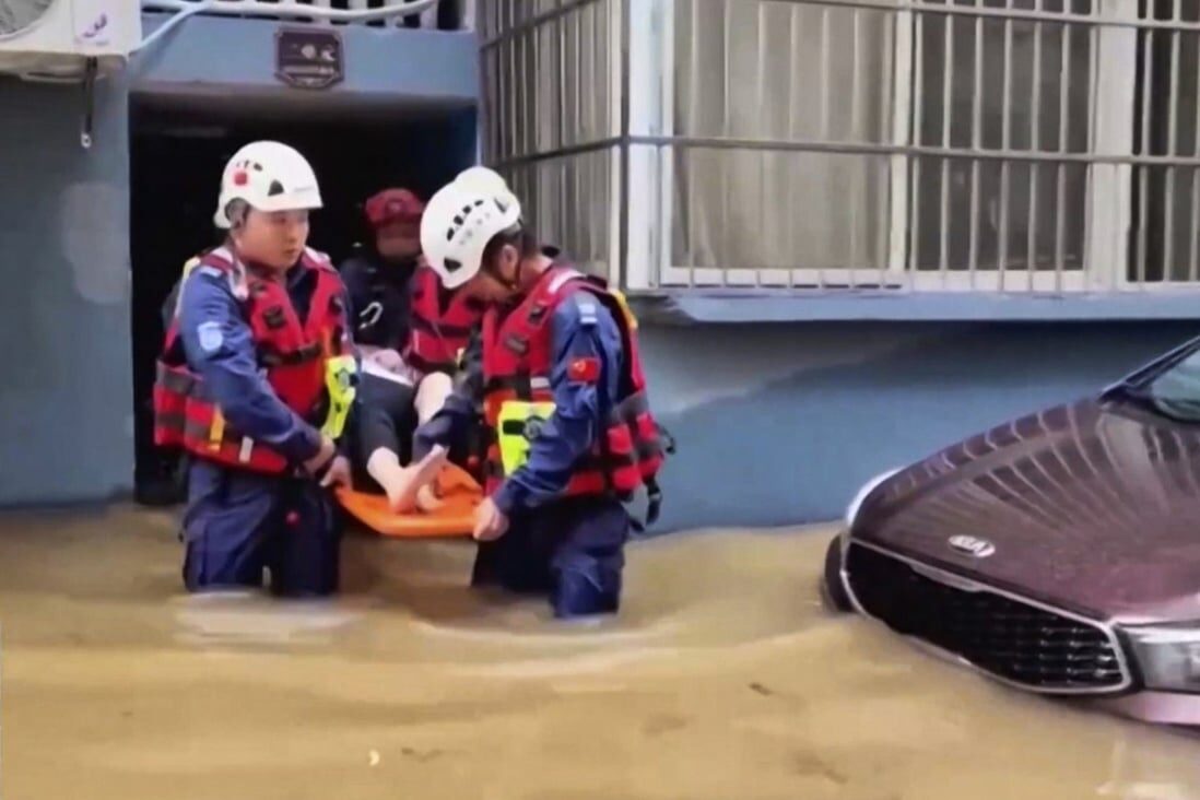 Rescuers aid a resident in a flood-hit village in eastern China’s Zhejiang province on Sunday.
