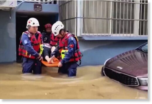 Rescuers aid a resident in a flood-hit village in eastern China’s Zhejiang province on Sunday.
