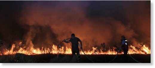 Clic para aumentar Firefighters attempt to extinguish a fire that razes through a peatland field in Ogan Ilir South Sumatra, Indonesia, Tuesday, Sept. 12, 2023.