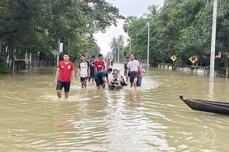 Local residents wade through a flooded road in Bago, about 80 kilometers (50 miles) northeast of Yangon, Myanmar, Monday, Oct. 9, 2023.