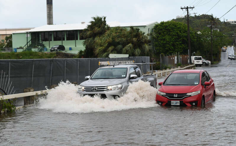 Drivers did their best to navigate flooding yesterday morning after heavy rainfall across the island. Pictured: cars on Woodlands Road