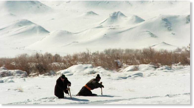 Men use sticks to wade through deep snow in rural Khovd province in far-western Mongolia. (file)