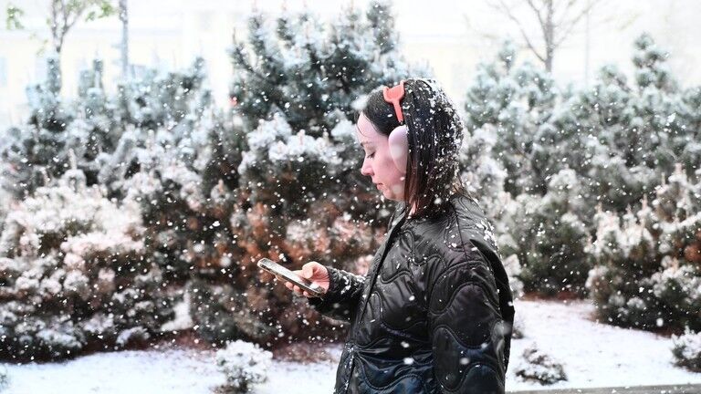 Clic para aumentar A woman walks along a street during rare spring snowfall in Moscow, Russia.