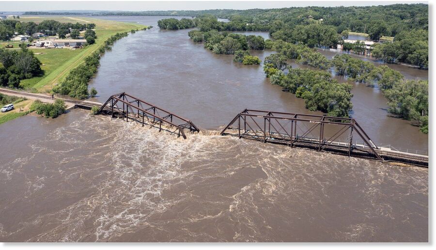 Floodwaters pass over a collapsed railroad bridge over the Big Sioux River near North Sioux City, S.D., on Monday, June 24, 2024.