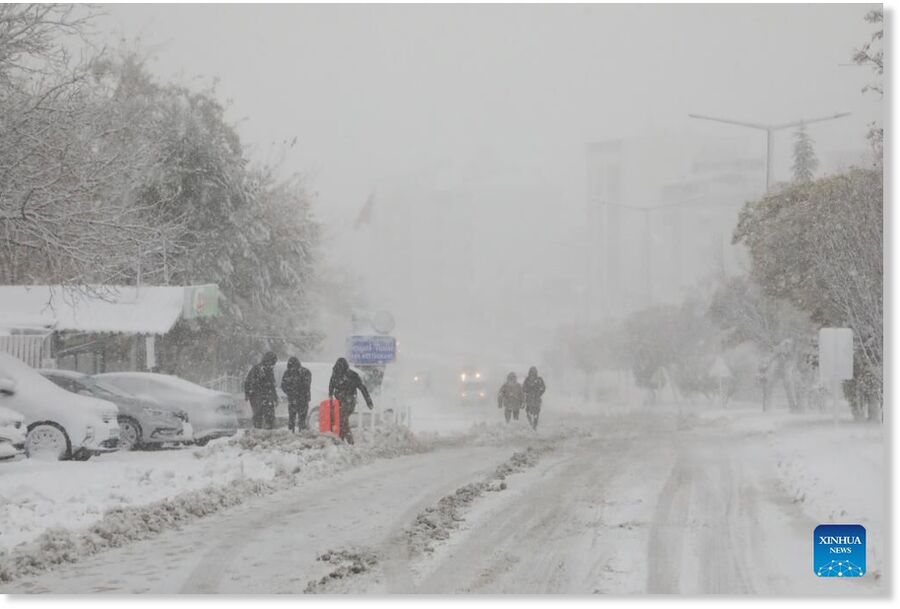 Clic para aumentar People walk on a snow-covered road in Malatya, Türkiye, on March 21, 2025. Heavy snowfall has impacted Türkiye