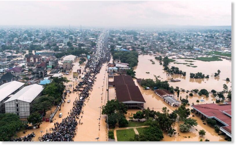 People walk through the flooded streets of Kinshasa, DR Congo, April 6, 2025.