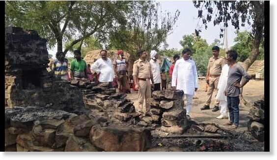 Officials inspect the scene where a hut was reduced to ashes in a lightning strike, killing four members of a family, in Prayagraj.