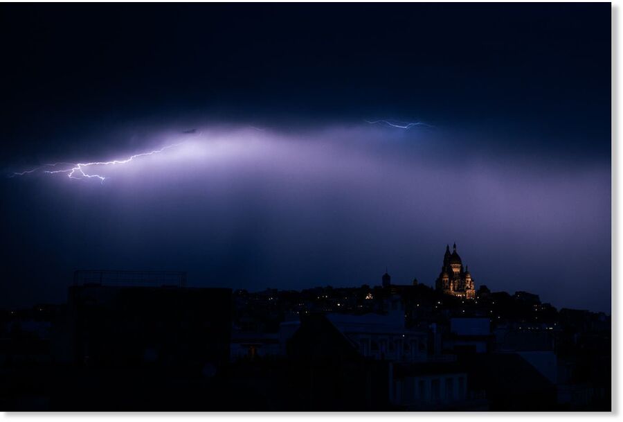 A lighting bolt lights up the sky over Sacre Coeur Basilica in Montmartre during a thunderstorm, northern Paris, on June 25, 2025