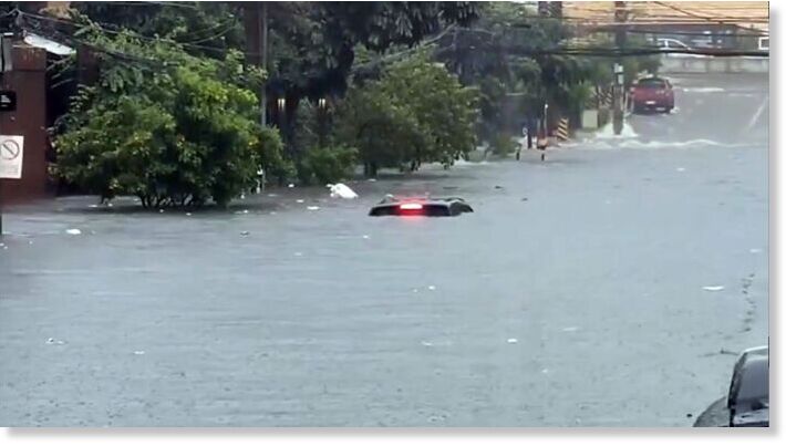Only the top part of a pickup truck can be seen in a flooded area along Mother Ignacia Ave. in Quezon City Saturday afternoon.
