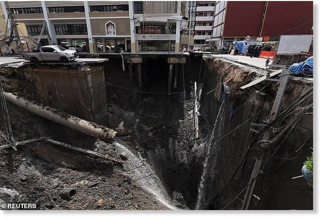 A vehicles stands near a massive sinkhole that opened on Samsen Road near Vajira Hospital, in Bangkok, Thailand, September 24, 2025