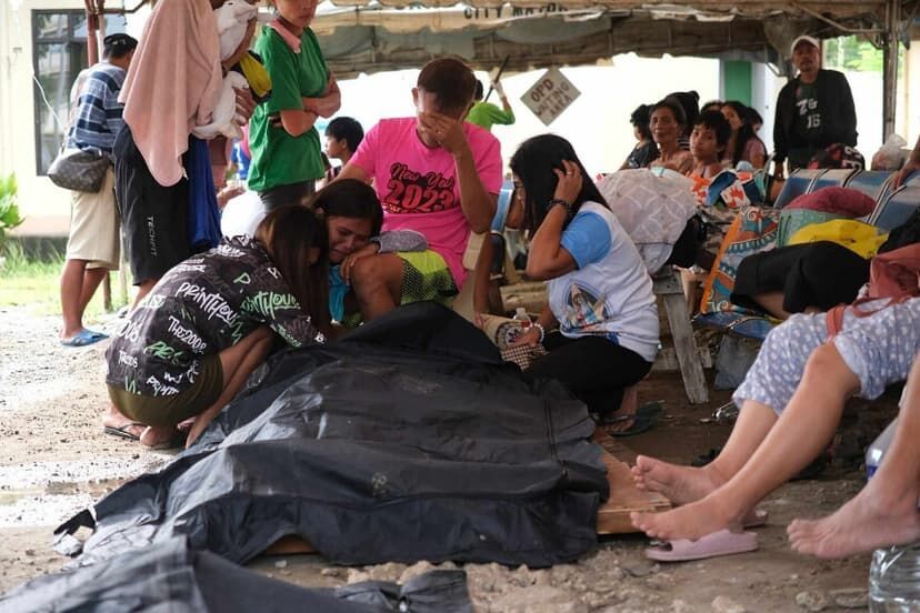 Tras terremoto, varias personas lloran junto a una bolsa para cadáveres en la ciudad de Bogo, provincia de Cebú,