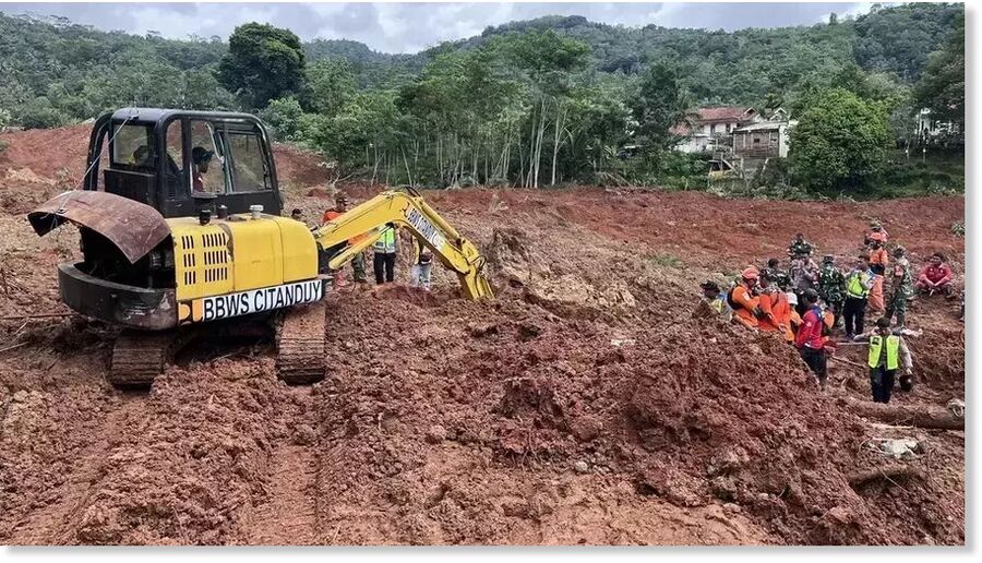An excavator digs through the soil in a search effort for landslide victims in Cibeunying Village, Cilacap Regency, Central Java, Friday, Nov. 14, 2025.