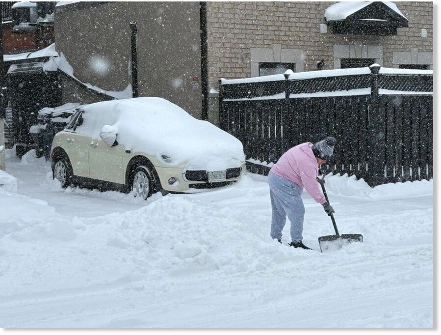 A person clearing snow on a side street near Lansdowne Avenue and Dupont Street.