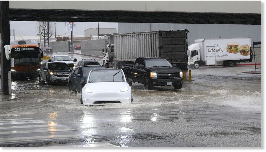 Clic para aumentar Cars pass on flooding water at Sawtelle neighborhood during heavy rain in Los Angeles, California, United States on February 16, 2026.