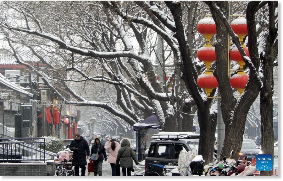 Citizens walk on a street in Beijing, capital of China, on March 5, 2026. Beijing has witnessed a spring snowfall from Wednesday to Thursday.