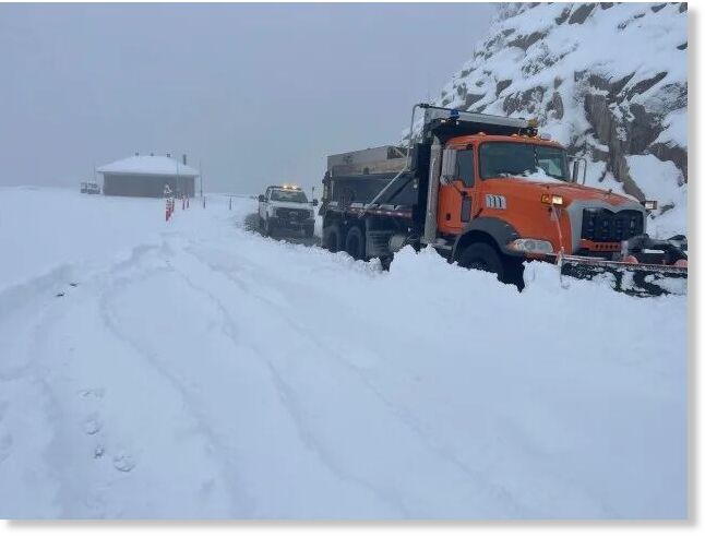 A plow truck clearing snow on the road at Rainbow Curve, taken on the morning of May 19, 2026.