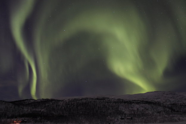 Una hermosa aurora boreal ilumina el cielo sobre el paisaje nevado de Tromsø, Noruega